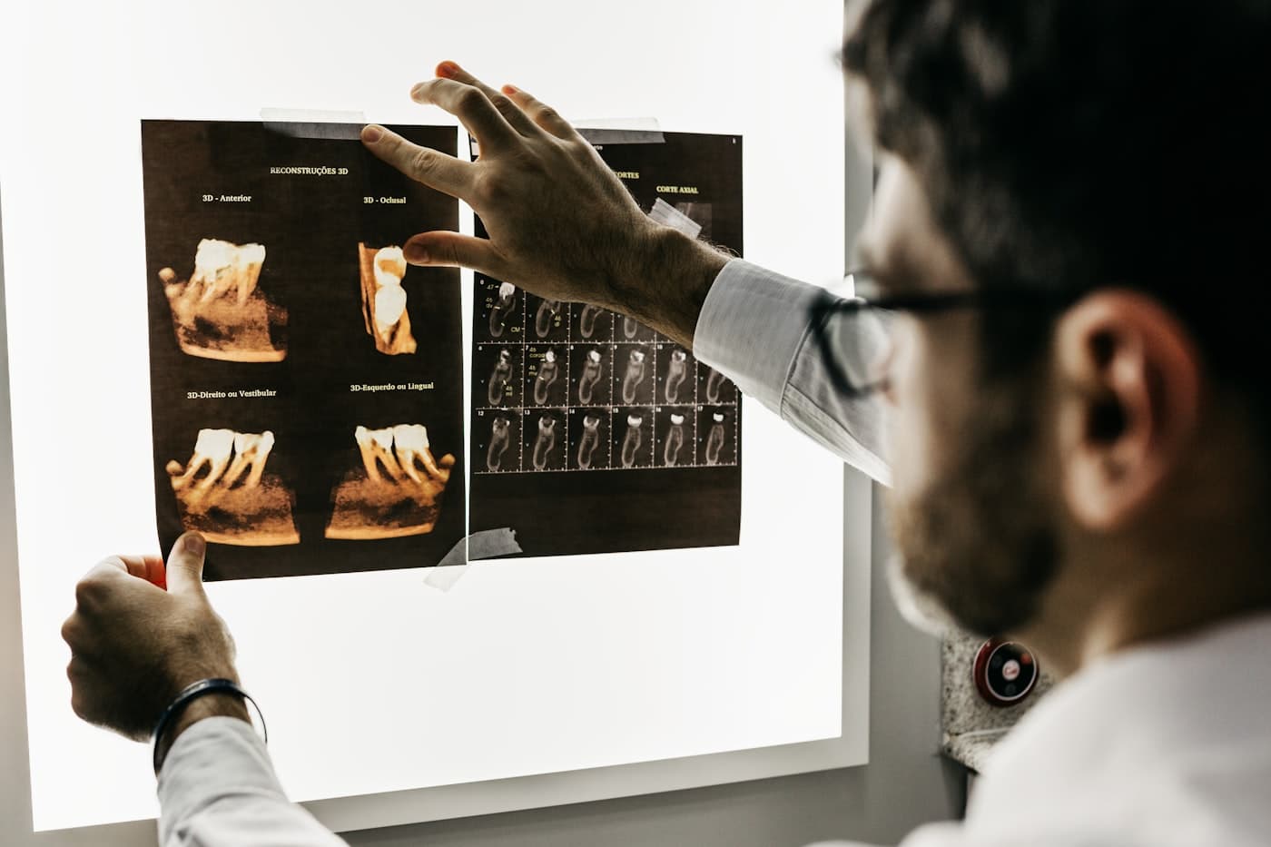 Dentista analisando exames de imagem para investigação óssea